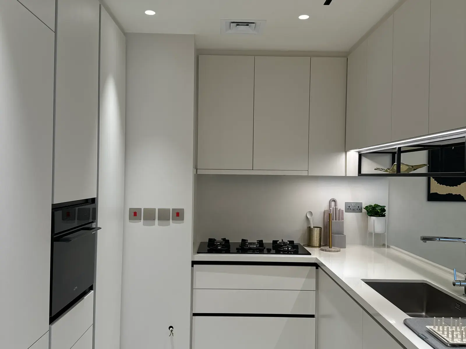 Handleless galley kitchen in white with integrated black appliances