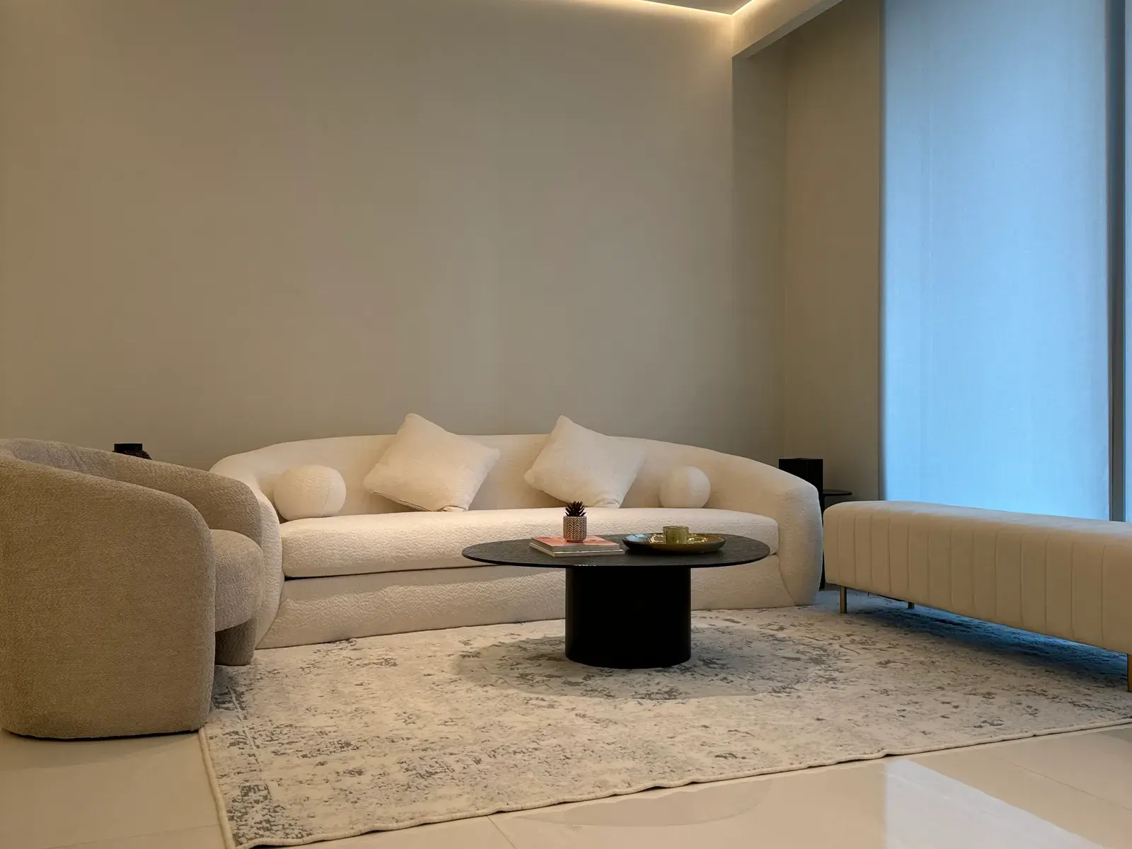 Living room with a curved boucle sofa and a round black coffee table