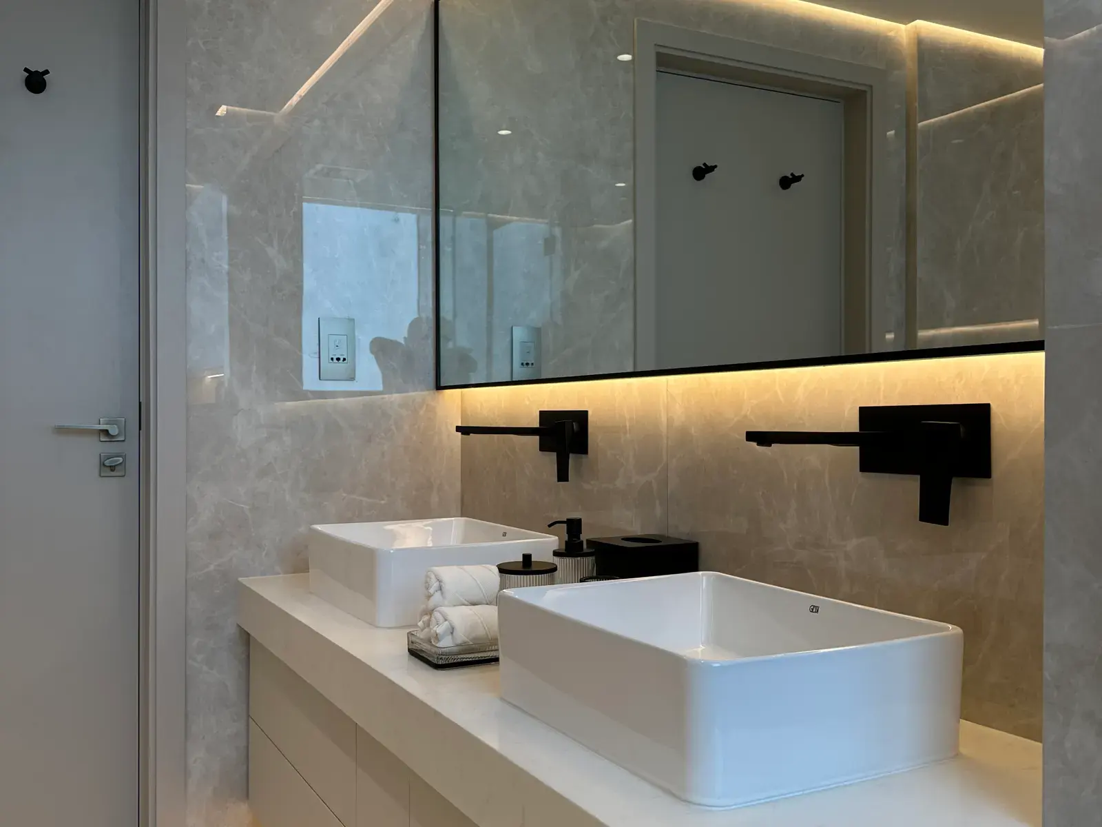 Stone vanity with a counter-top basin and matte black wall-mounted tap