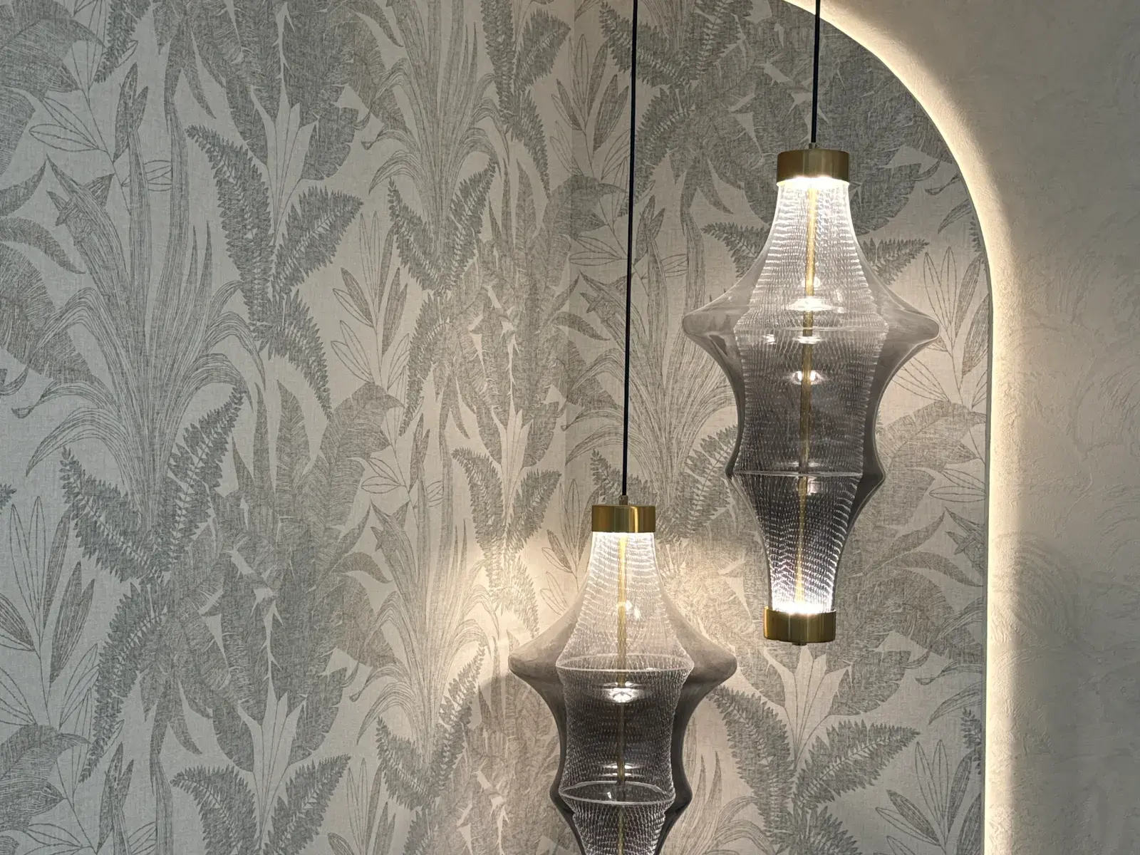 Glass pendants hung against a botanical damask wallcovering