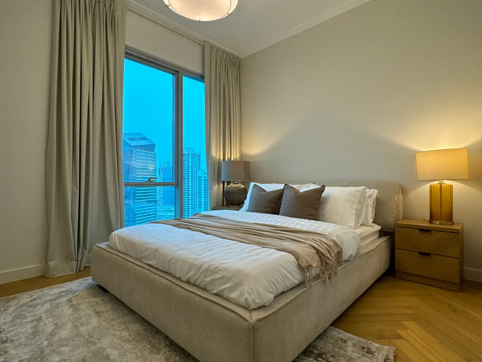 Principal bedroom with an upholstered bed and herringbone oak floor