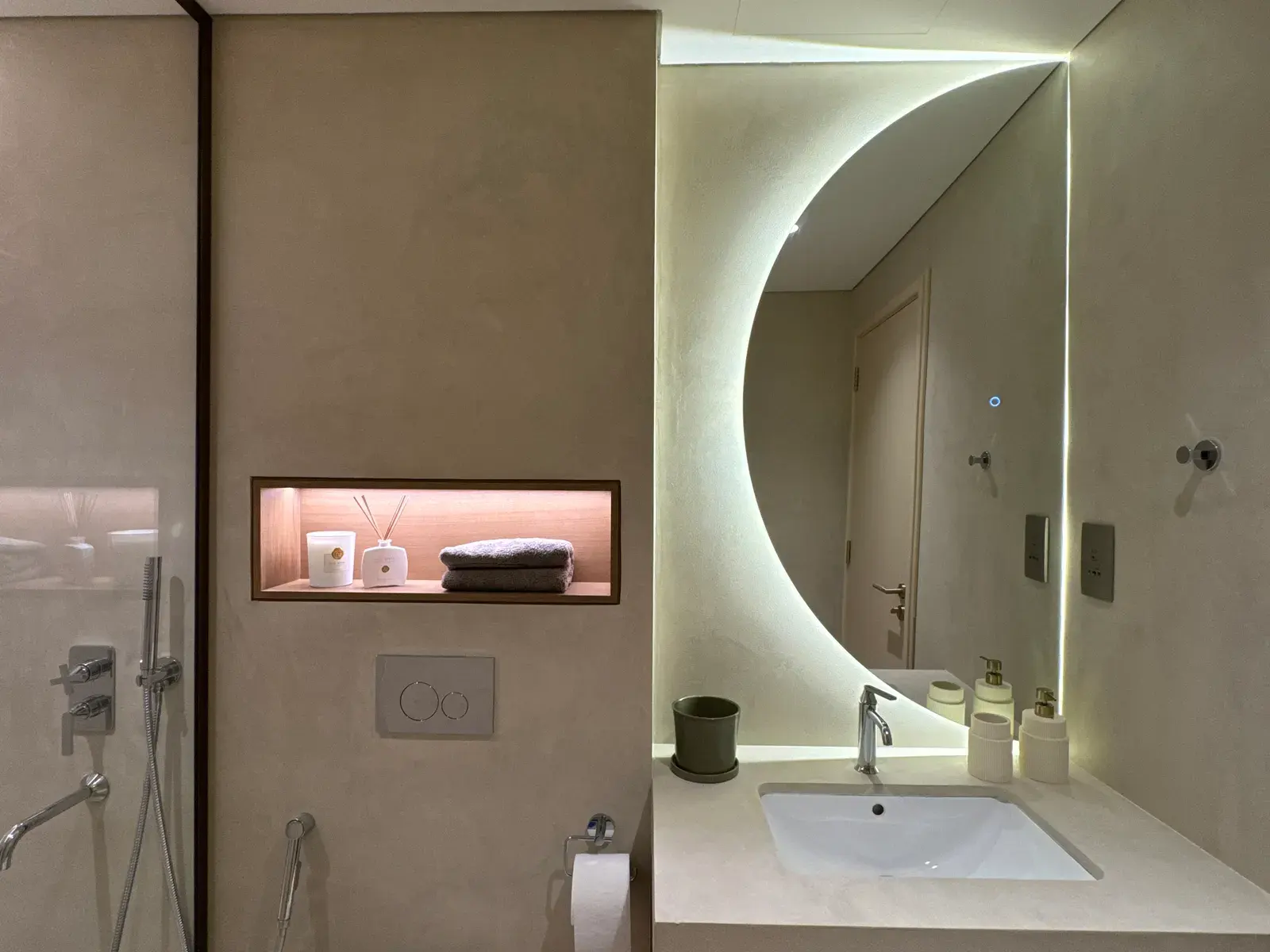 Microcement vanity wall with an arc-shaped backlit mirror