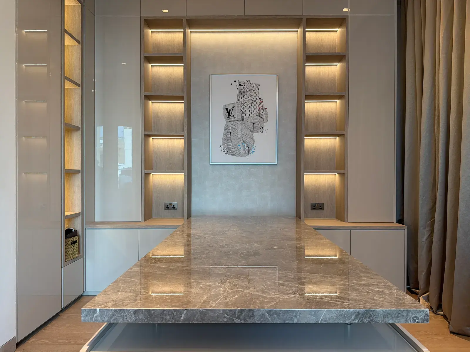 Dining room with a marble table between two walls of backlit display niches