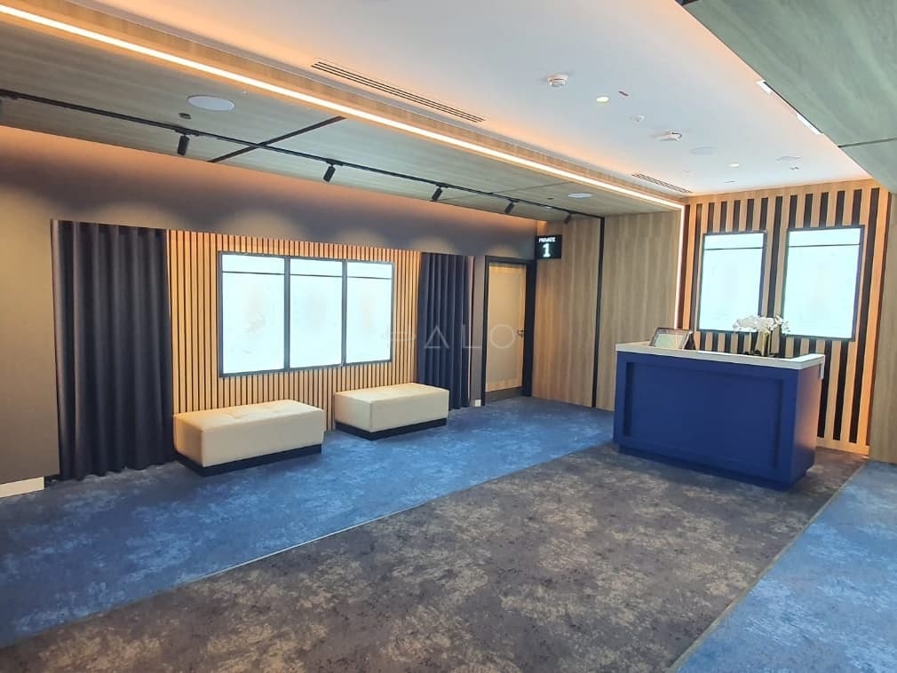 Stepped gypsum ceiling with concealed cove lighting and a linear reveal in a Dubai commercial interior