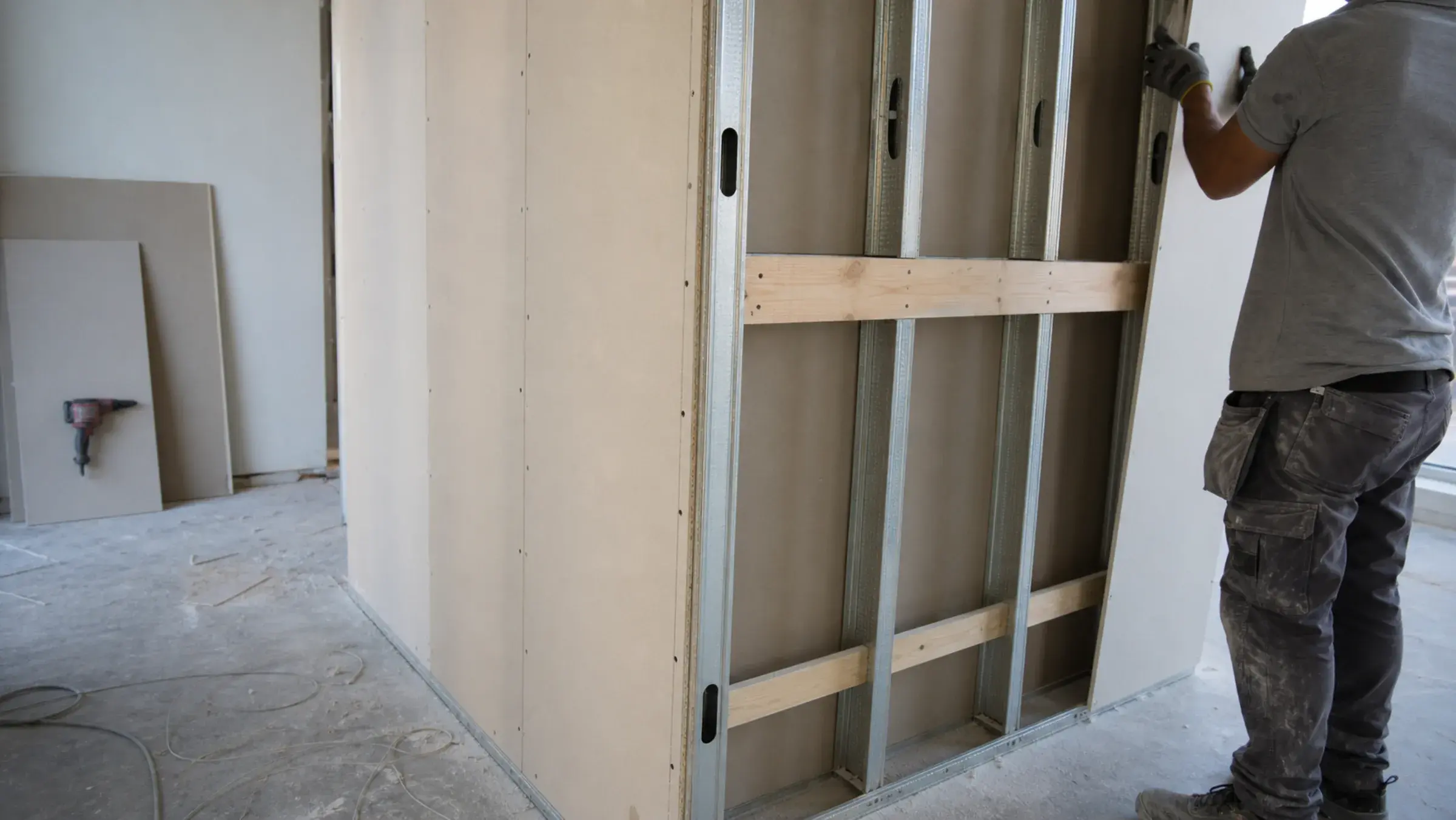 Metal stud partition part-boarded in a Dubai fit-out, with timber pattress noggins fixed between the studs before the second face is closed