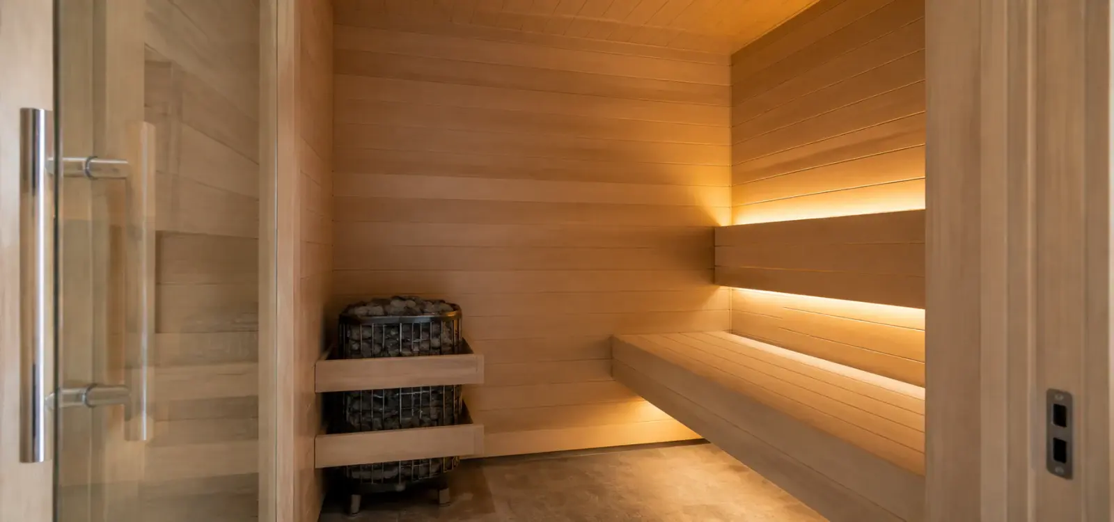 Cedar sauna with tiered benching, a heater and warm concealed lighting