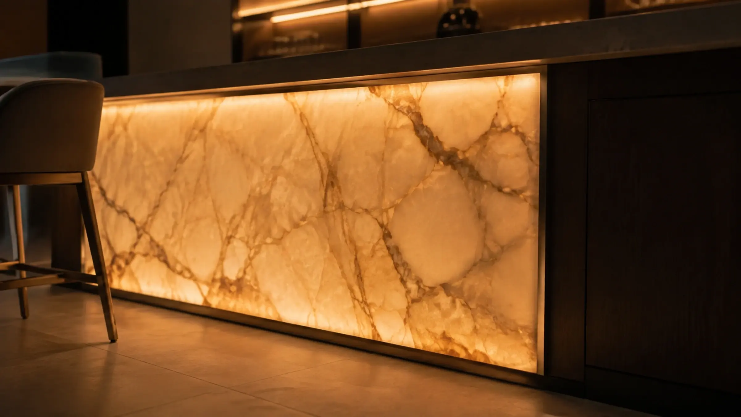 Close view of a warm backlit onyx bar front casting light across a matt porcelain floor