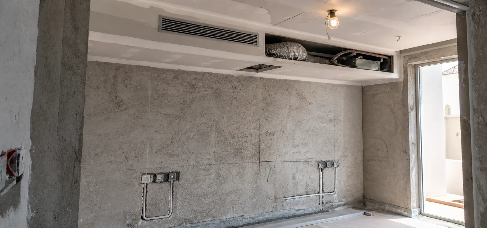 Bedroom ceiling and wall services set out during a Dubai renovation, with a linear AC grille and socket positions marked