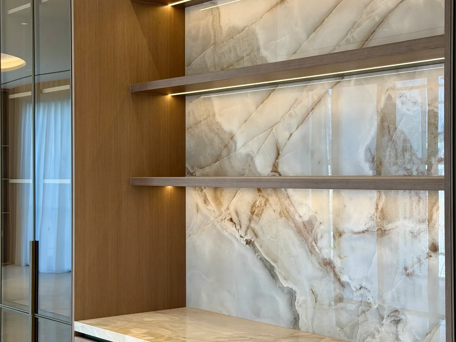 Backlit onyx wall with floating timber shelves