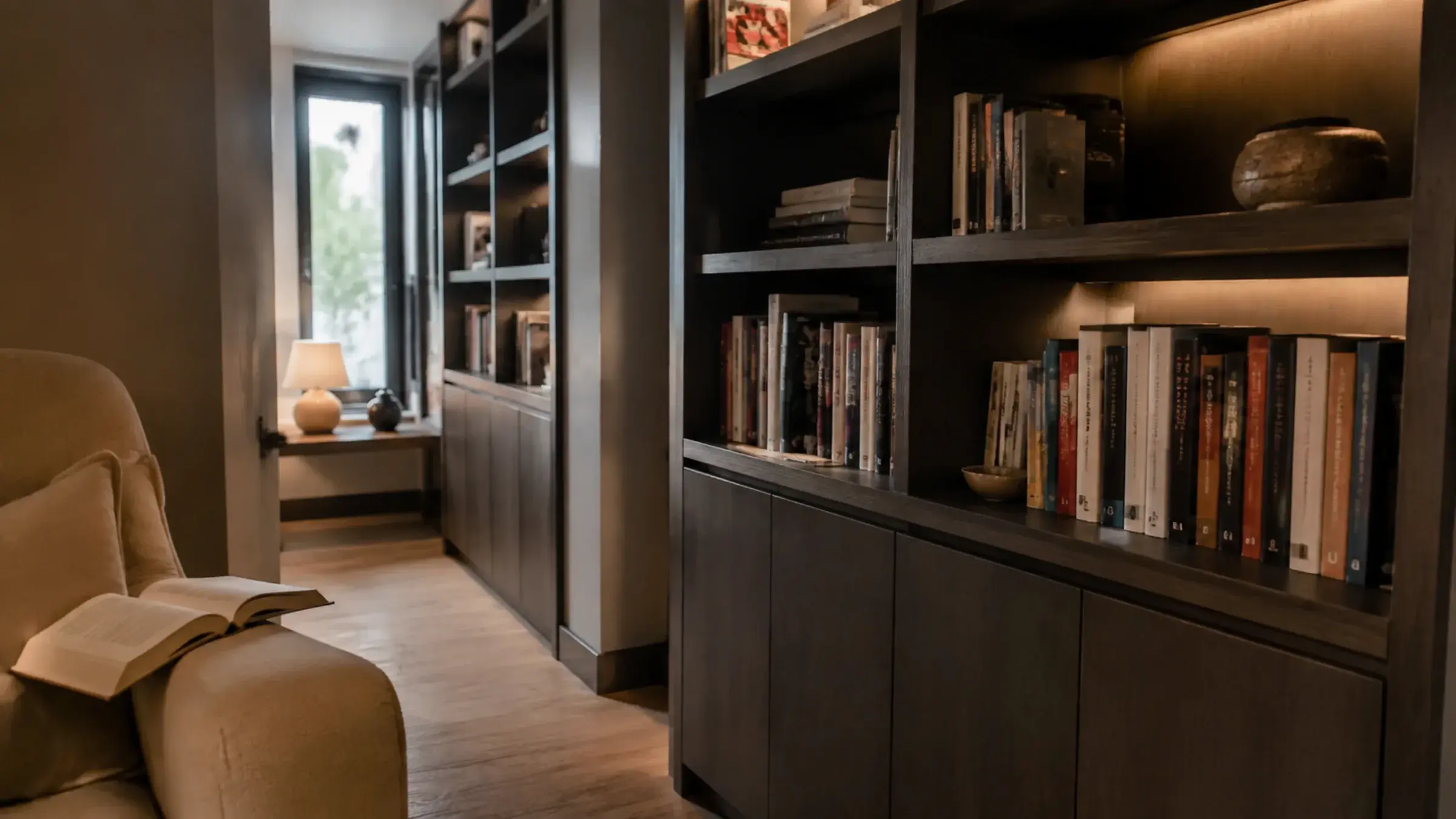Dark timber home library with built-in shelving and integrated lighting