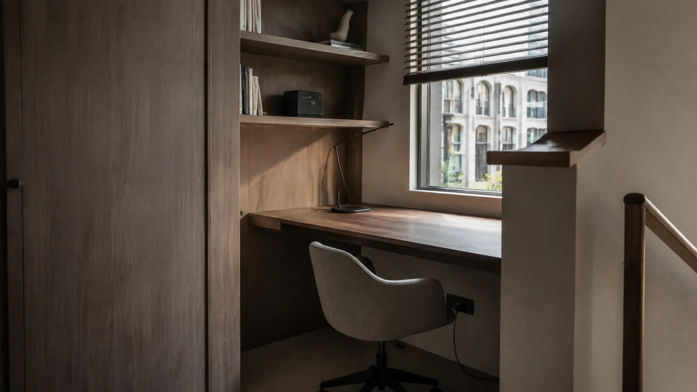 Compact contemporary home office with a built-in timber desk and floating shelving