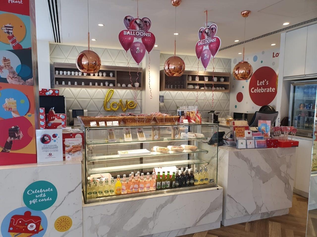 Gift and confectionery kiosk with refrigerated display, shelving and illuminated branding in Dubai