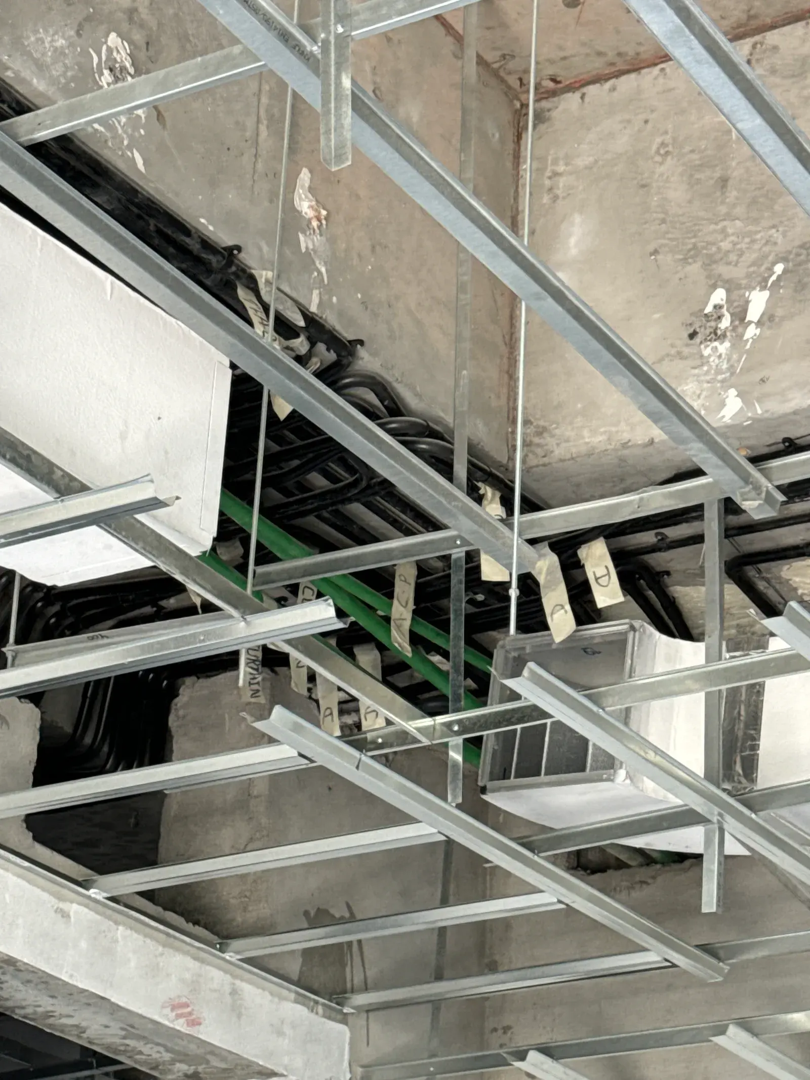 Perforated cable tray with bundled cabling installed on a ceiling grid in a Dubai fit-out