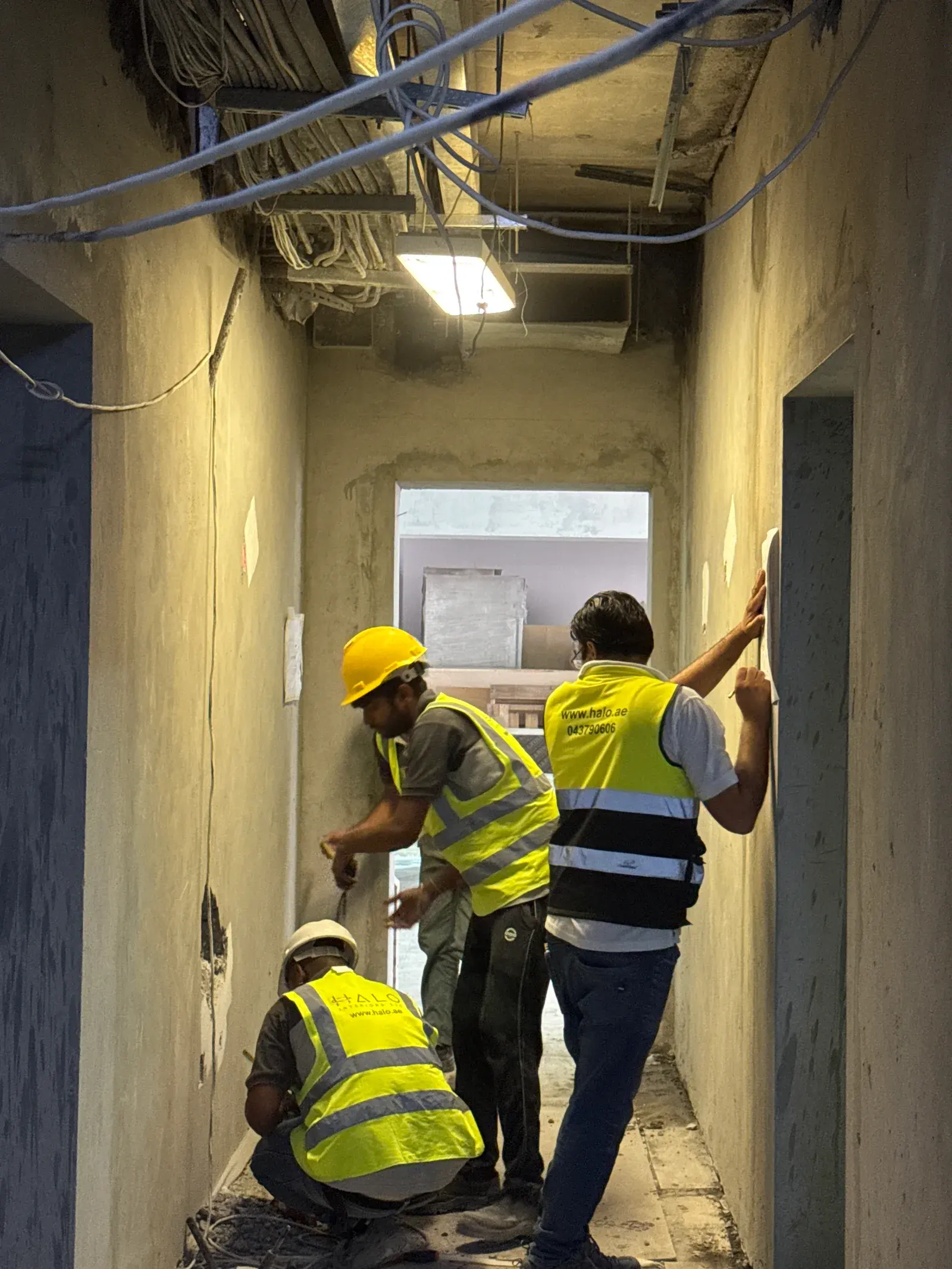 Halo MEP crew in branded hi-vis working through second fix on a Dubai commercial unit