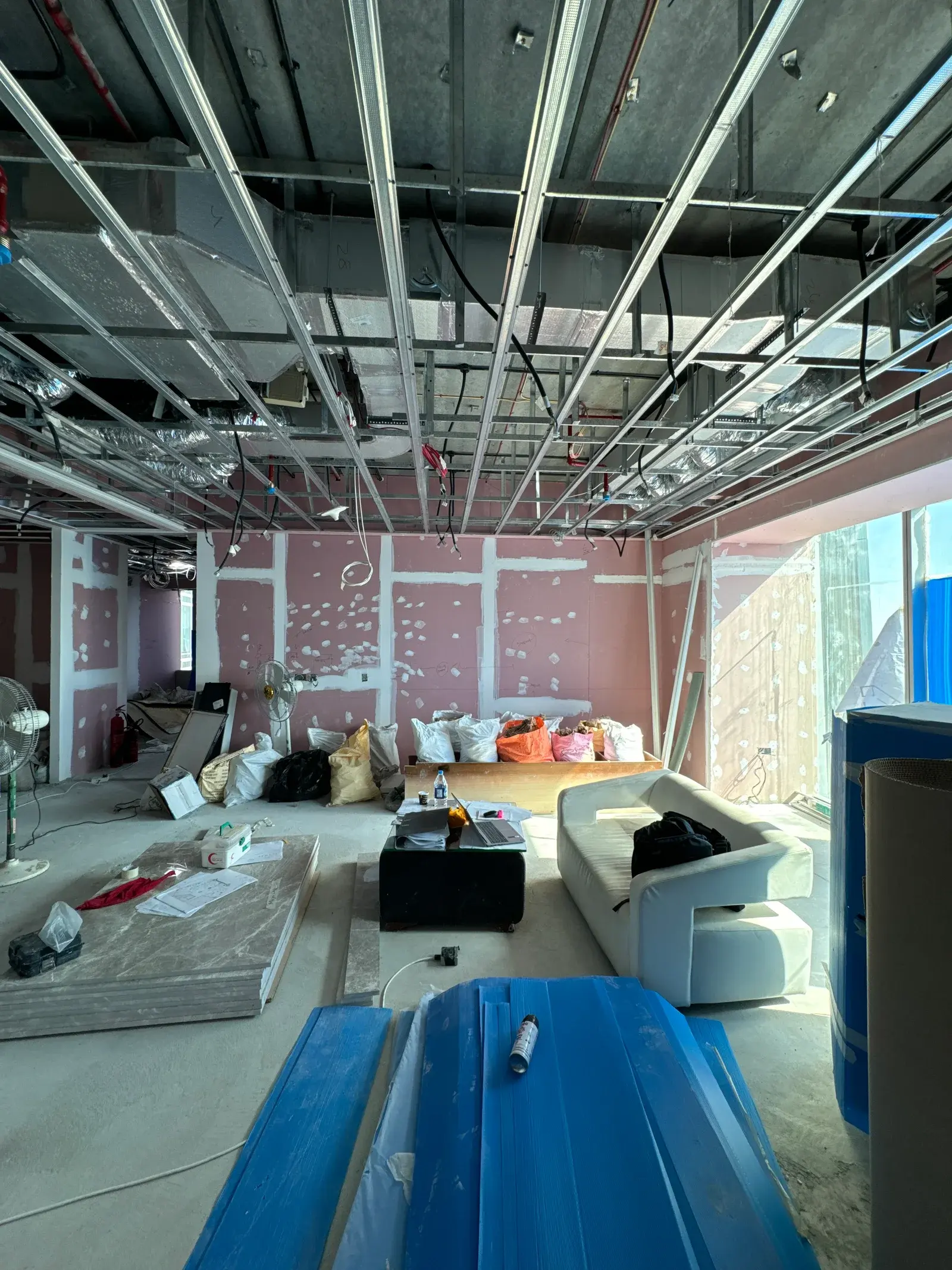 Ceiling grid set out against coordinated MEP services in a Dubai commercial fit-out