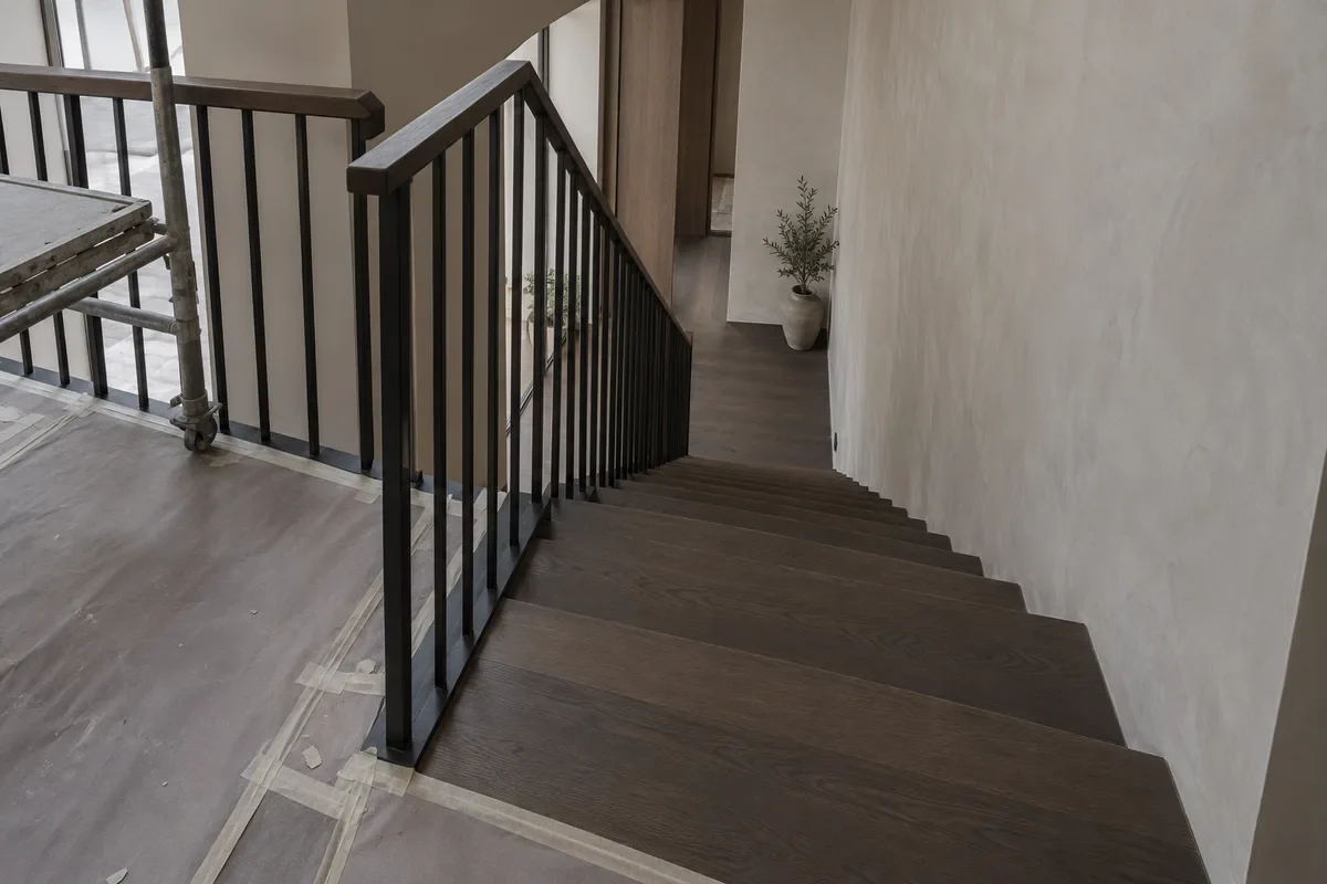 Duplex penthouse stair with black steel balustrade and protected flooring