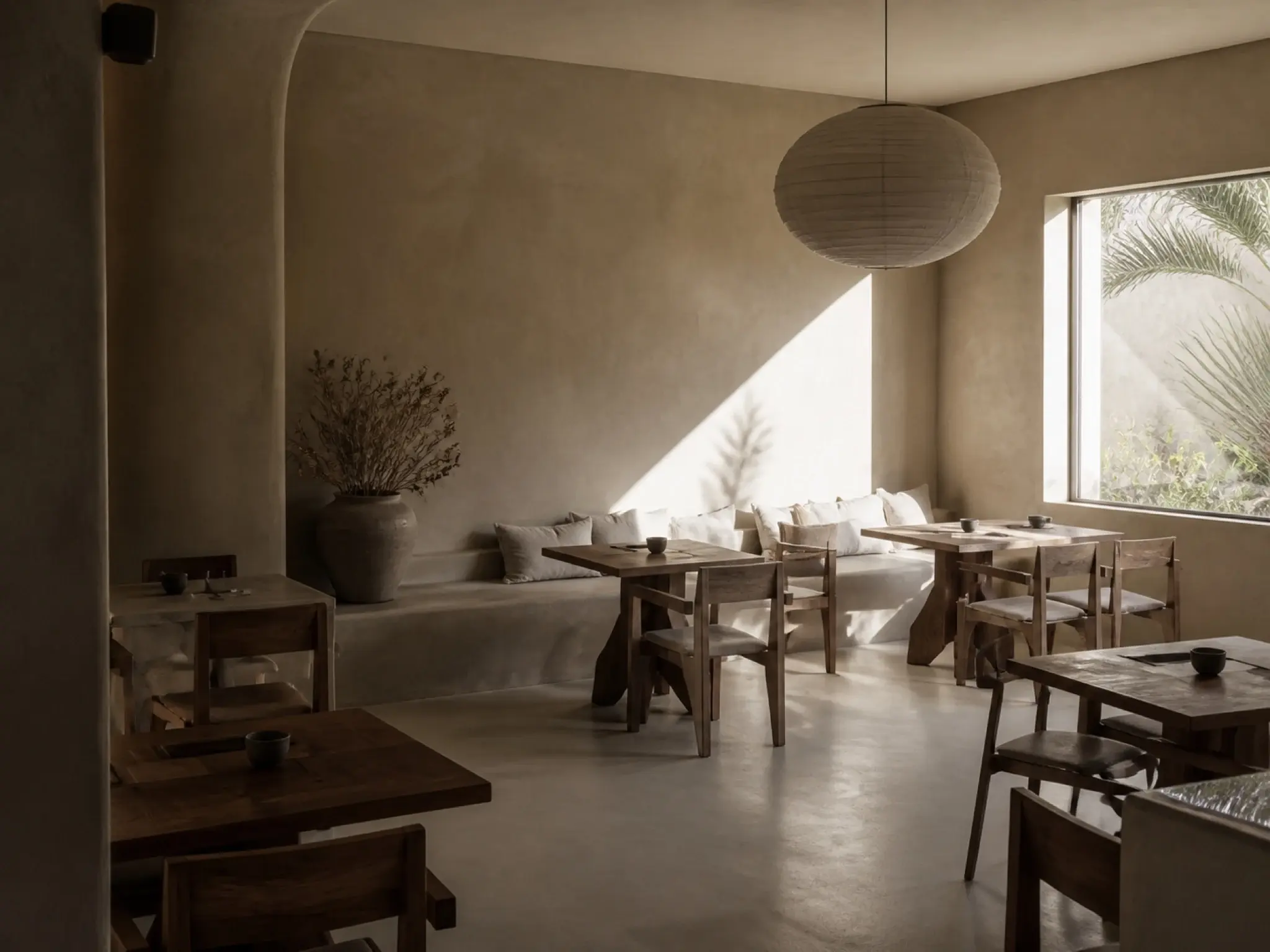 Desert modern restaurant interior in sand-toned micro-cement with sculptural minimal seating