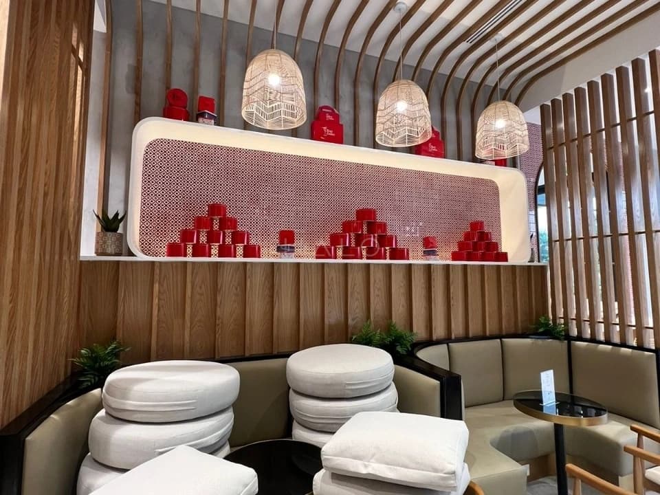 Pedicure area in a Dubai salon fit-out with pendant lighting, upholstered seating and a tiled product shelf