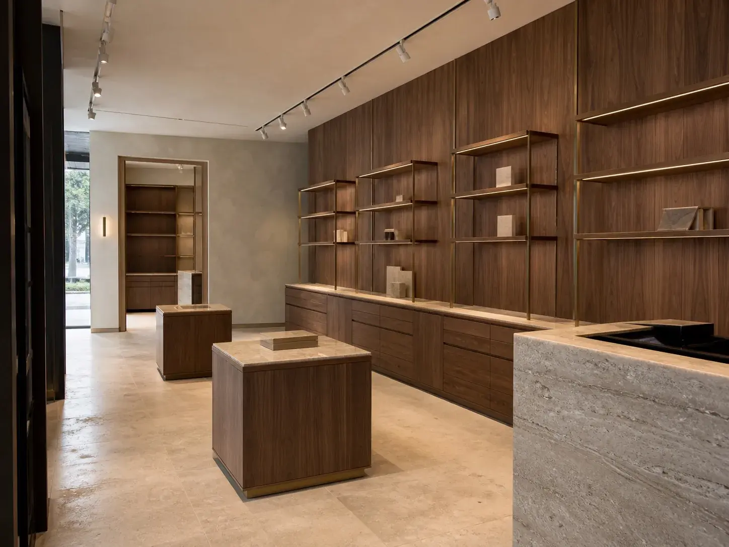 Bespoke walnut display bays, plinths and a stone-topped counter produced in Halo’s Dubai joinery factory